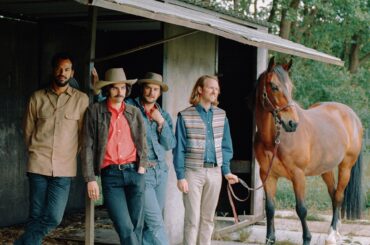 Mannen en paard bij stal in natuur.