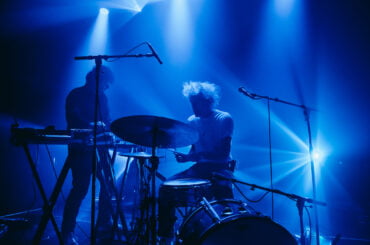 Muzikanten spelen in blauw verlichte concertzaal